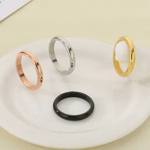 Anelli minimalisti in acciaio al titanio lucido in quattro colori metallici su un piatto bianco.