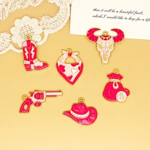 Detailed view of pink enamel Western cowboy themed charms including boot, hat, and revolver