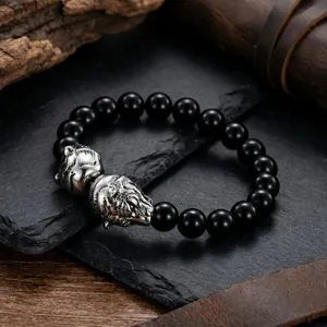 Vue détaillée de la tête de tigre en acier titane sur bracelet perlé noir homme