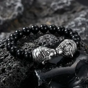 Vue détaillée des têtes de tigre en argent sculptées sur ce bracelet en perles noires