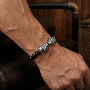 Vue détaillée d'un bracelet pour homme en perles noires avec têtes de tigre en argent.