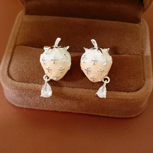 Close-up detail of strawberry enamel earrings with silver needle and teardrop zirconia
