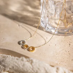 Elegant close-up of minimalist 18k gold plated stainless steel multi-ring pendant necklace