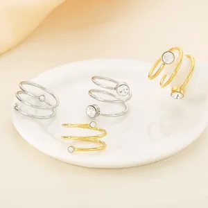 Minimalist stainless steel spiral coil rings with zircon accents on a ceramic plate