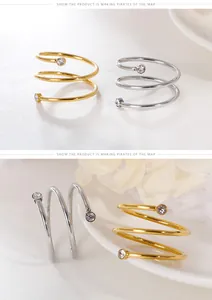 Close-up detail of stylish gold and silver spiral stainless steel rings with zircon stones.