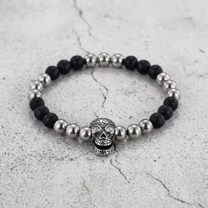 Close-up of punk beaded bracelet with black matte beads and silver skull charm