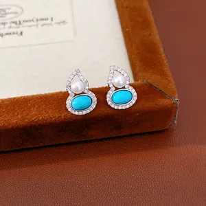 Detailed view of elegant silver gourd-shaped earrings featuring pearls and turquoise stones