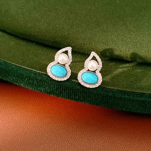 Exquisite close-up view of gourd-shaped stud earrings featuring turquoise and white pearls