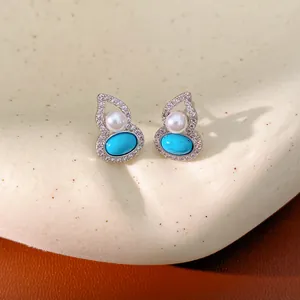 Detailed view of elegant gourd-shaped pearl earrings with turquoise and zircons