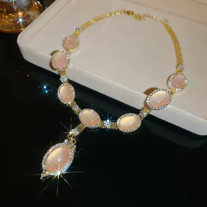 Détail d'un collier de style palais avec des pierres oeil-de-chat roses et cristaux