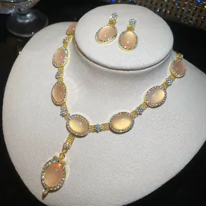 Ensemble collier et boucles d'oreilles œil de chat pêche avec strass en finition dorée