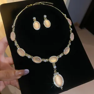 Vue détaillée de l'élégant ensemble de bijoux collier et boucles d'oreilles œil de chat
