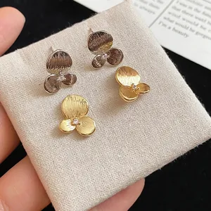 Boucles d'oreilles trèfle élégantes en argent et or avec zircons et fini texturé