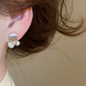 Vue détaillée d'une élégante boucle d'oreille fleur argentée avec un zircon brillant