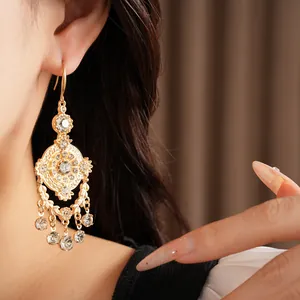 Gros plan sur des boucles d'oreilles vintage style palais doré avec motifs d'épis de blé.