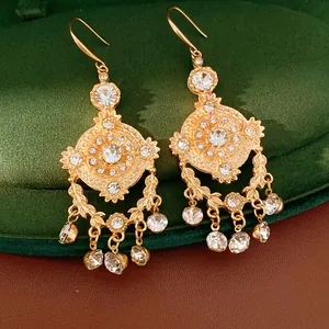 Gros plan de boucles d'oreilles vintage dorées avec strass et motif d'épi de blé