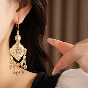Gros plan détaillé de boucles d'oreilles style palais vintage ajourées avec strass