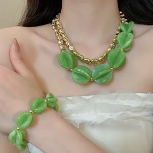 Vista detallada del conjunto de collar y pulsera de cuentas acrílicas verdes en modelo