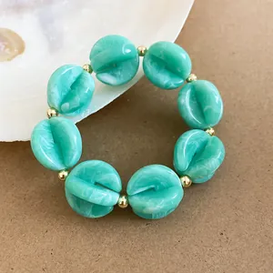 Imagen detallada de pulsera de cuentas de acrílico turquesa con espaciadores oro.