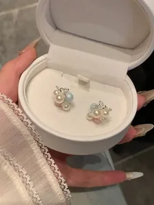 Close-up of sweet grape-shaped stud earrings with colorful pearls in a white box.