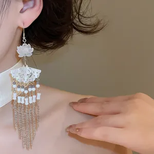 Close-up detail of New Chinese style fan-shaped earrings with white flower and long tassels