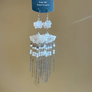 Detailed view of Chinese style flower fan earrings with elegant long silver tassels