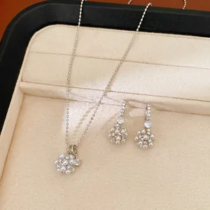 Close-up of pearl and zirconia cluster jewelry set featuring floral necklace and earrings