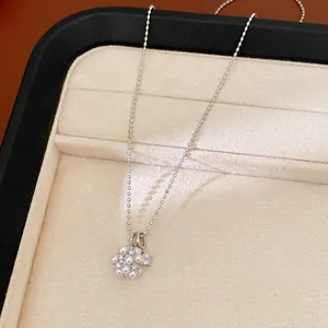 Close-up of elegant zircon cluster pearl pendant necklace on a beige jewelry display tray