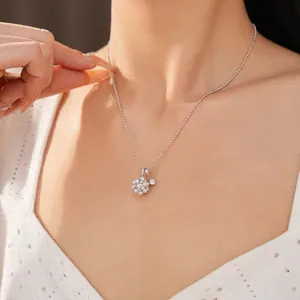 Elegant detail of a zircon flower cluster and pearl necklace worn on a model's neck.