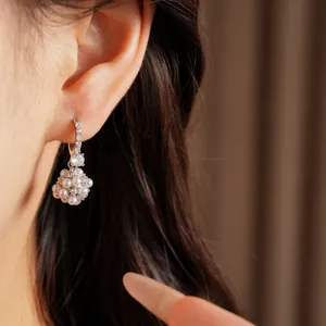 Close-up detail of elegant pearl cluster earrings with sparkling zircon accents