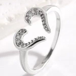 Macro detail of adjustable silver-toned ring with heart-shaped cubic zirconia inlay