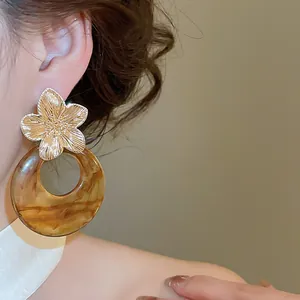 Close-up of elegant French retro flower stud earrings featuring a brown resin marble hoop