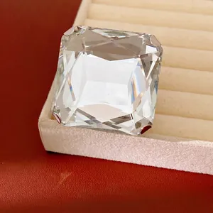 Boucle d'oreille élégante en cristal carré présentée sur un plateau en velours beige.