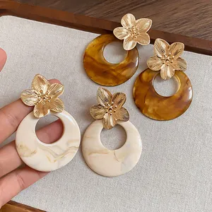 Detailed macro view of French retro metal flower earrings with round marble resin texture