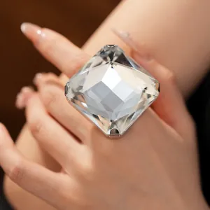 Gros plan d'une bague carrée en cristal surdimensionnée sur une main élégante