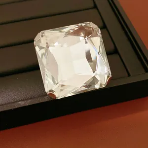 Détail macro d'une boucle d'oreille en cristal carré sur un plateau de présentation