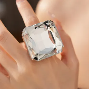 Gros plan d'une bague glamour surdimensionnée en cristal carré portée par un mannequin