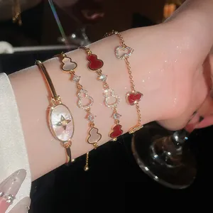 Detailed view of 18k gold plated gourd bracelets featuring red and white zircons on wrist