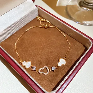 Close-up of elegant gold plated bracelet with zircon and heart charms in a box