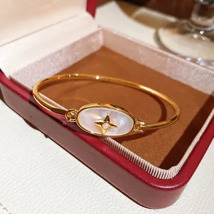 Close-up of elegant 18k gold plated bracelet with star-motif pearl inlay in gift box