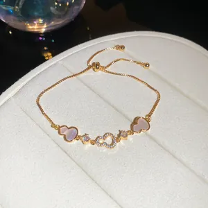 Detailed macro shot of 18k gold plated adjustable bracelet with zircon heart charms