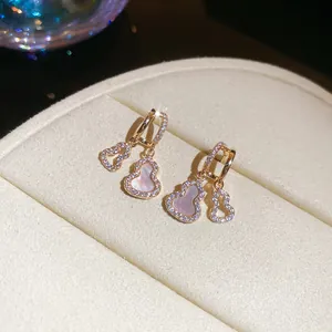 Detailed macro view of 18k gold plated hulu earrings with zircon and shell inlay