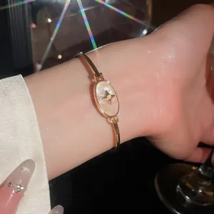Close-up of 18k gold plated bracelet with star motif and shell inlay on wrist
