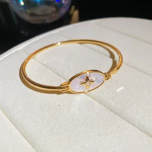 Elegant 18k gold plated bangle featuring a mother-of-pearl oval and North Star zircon detail.