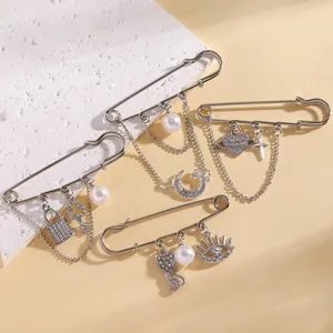 Detailed close-up of fashion safety pin brooches with sparkling rhinestone charms