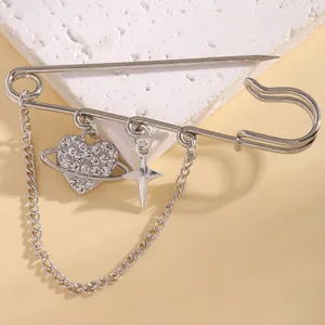 Detailed macro view of a silver safety pin brooch with crystal heart and star charms