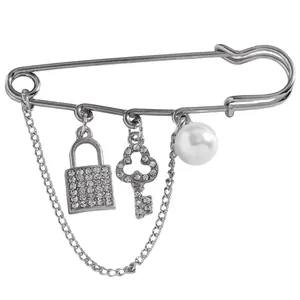 Elegant safety pin brooch featuring a crystal-encrusted lock, key, and pearl charms.