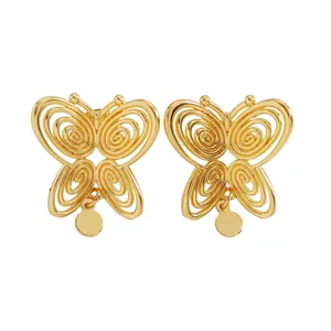 Macro view of vintage gold hollow spiral butterfly stud earrings with circular dangles