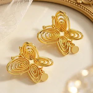 Close-up of vintage gold butterfly stud earrings with hollow spiral wing design.