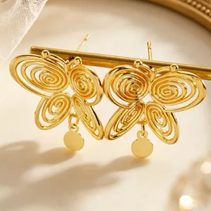 Close-up of retro hollow spiral butterfly gold stud earrings with dangling charms